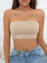Beige strapless top worn by a person with a blurred background